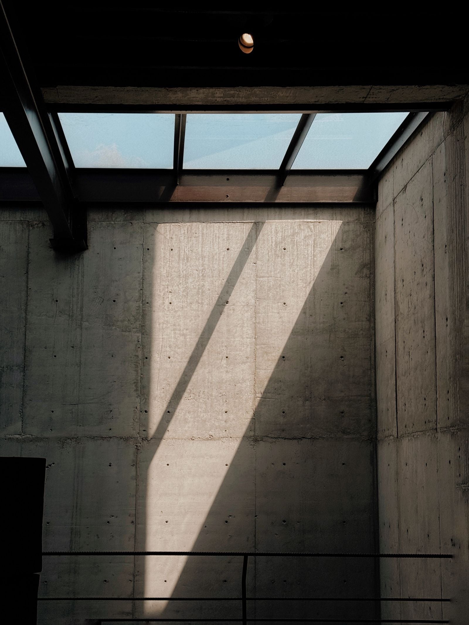 Daylight from a skylight washing down a concrete wall