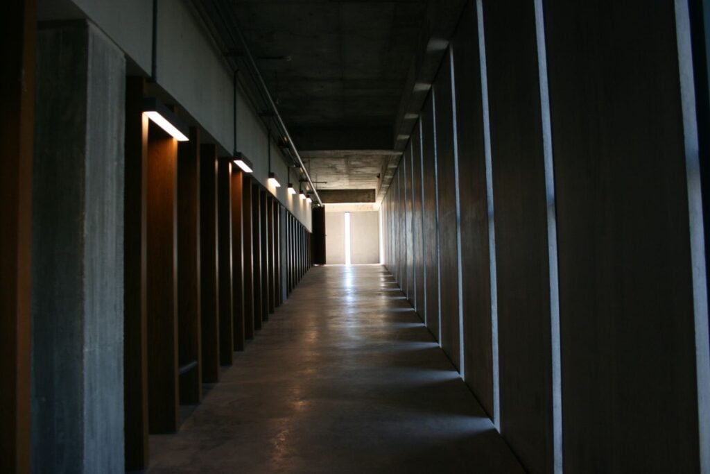 A long dark corridor with slots of daylight