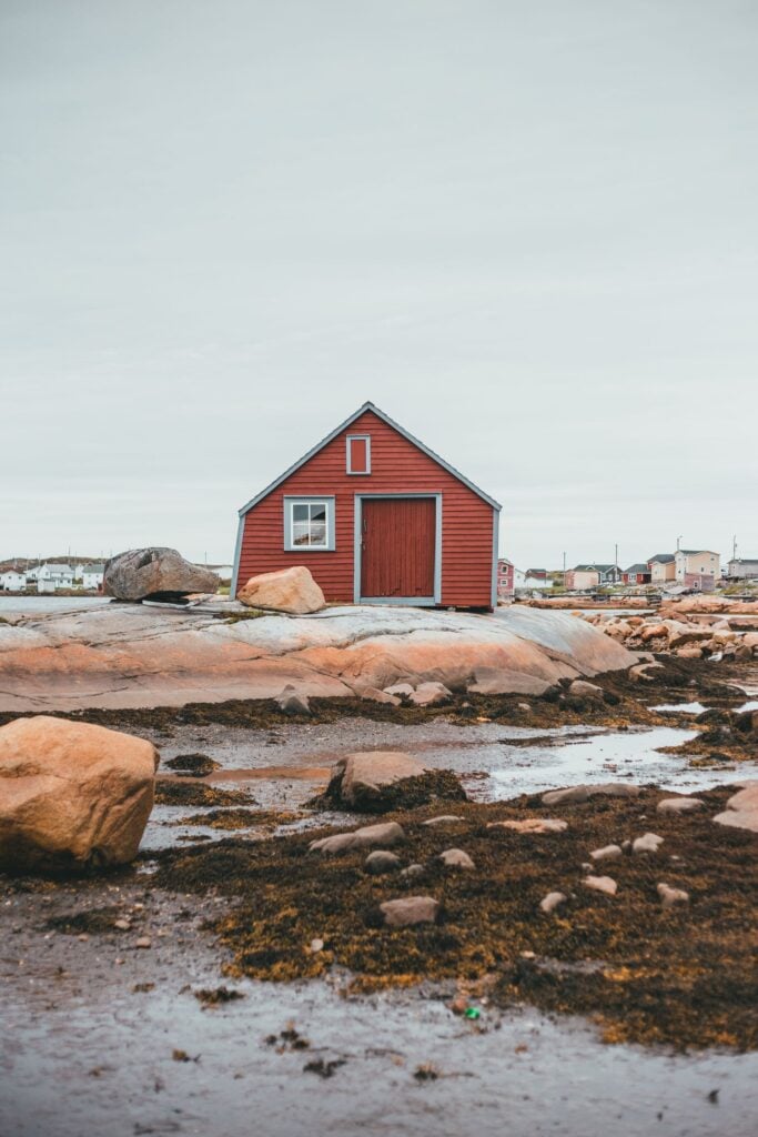 A red boathouse on pink granite by the sea