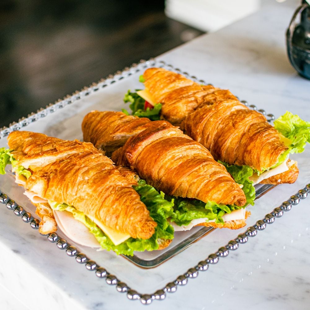 Croissant sandwiches with ham and salad on a tray