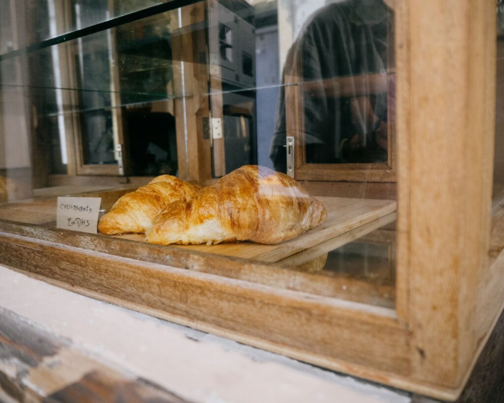 Fresh croissants on the counter of a sunny shop window