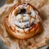 Cinnamon roll with caramel glaze on baking paper