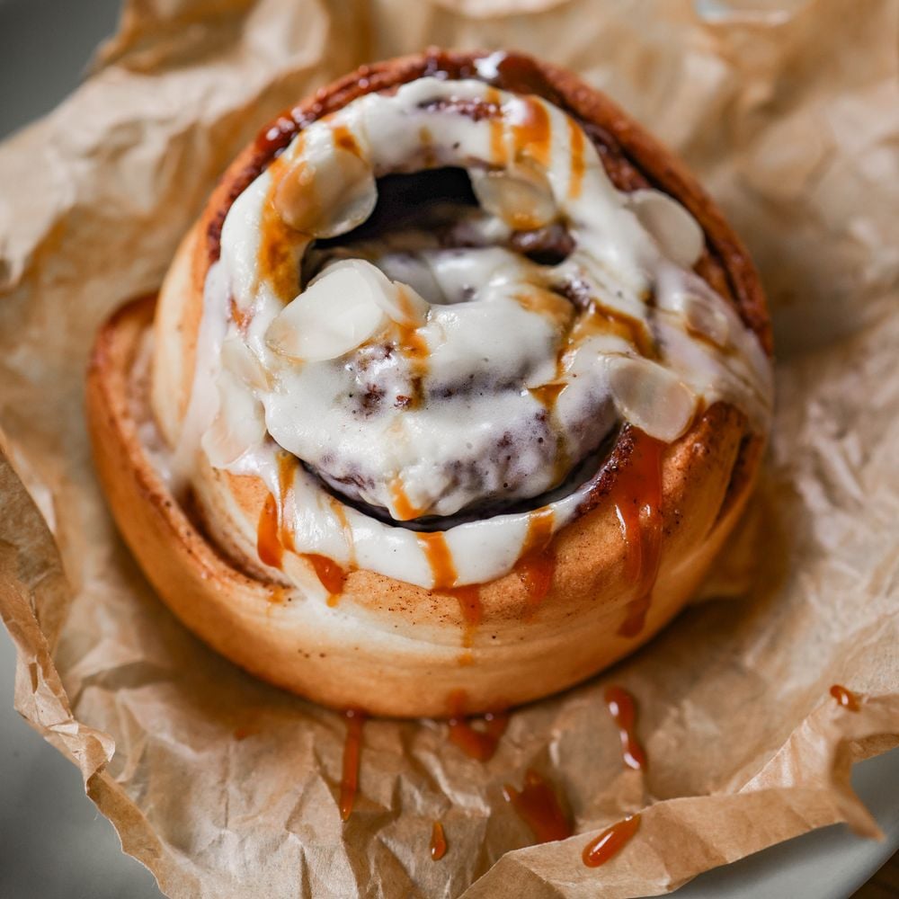 Cinnamon roll with caramel glaze on baking paper