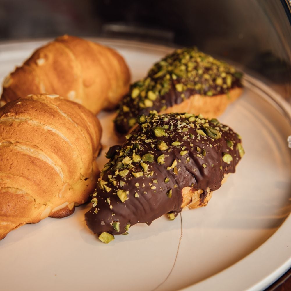 Croissants dipped in chocolate and chopped pistachio
