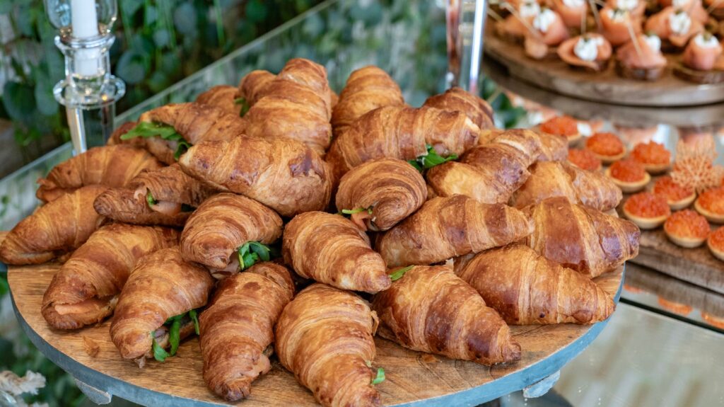 A large platter piled with golden croissants