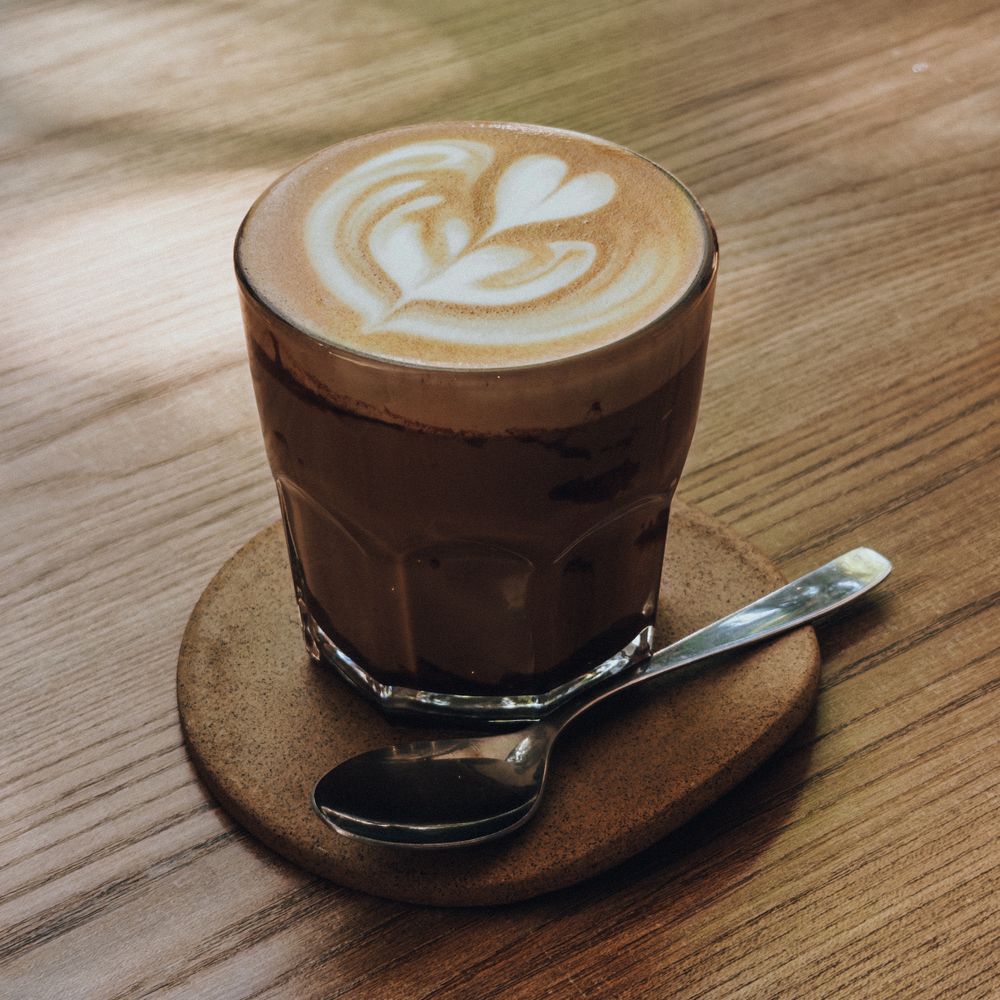 Cortado in a glass on a wooden table