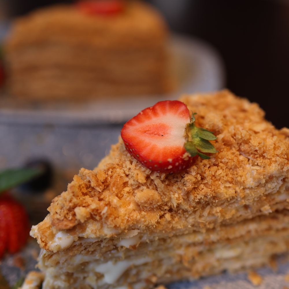 Slice of honey cake topped with a strawberry