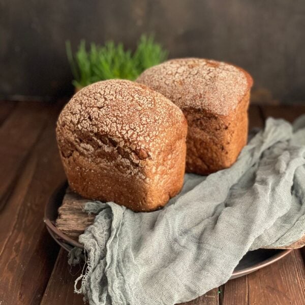 Two seeded rye loaves on linen