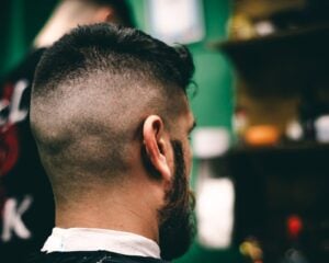 Back and side view of a fresh skin fade with a full beard