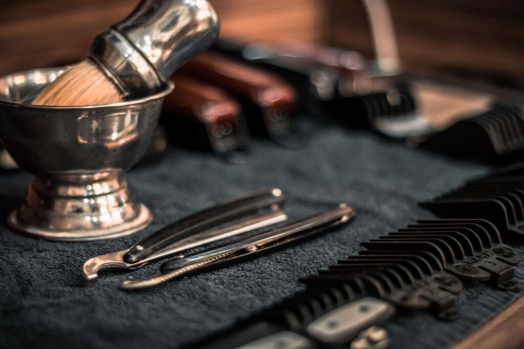 Shaving bowl, brush, razors and combs laid out on a dark towel