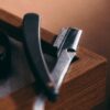 Straight razor resting on the edge of a walnut case