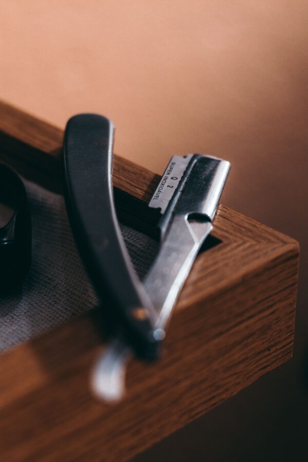 Straight razor resting on the edge of a walnut case