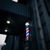 Barber pole on a dark storefront at dusk