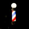 Lit barber pole glowing in the dark