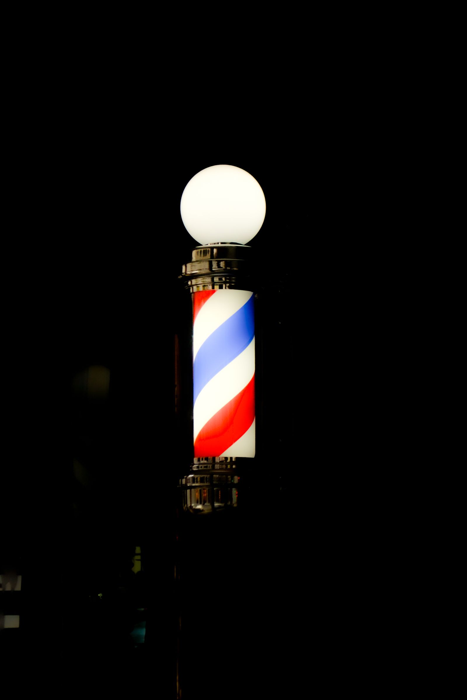 Lit barber pole glowing in the dark