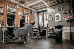 Barbershop interior with brick walls, chairs and a barber at work
