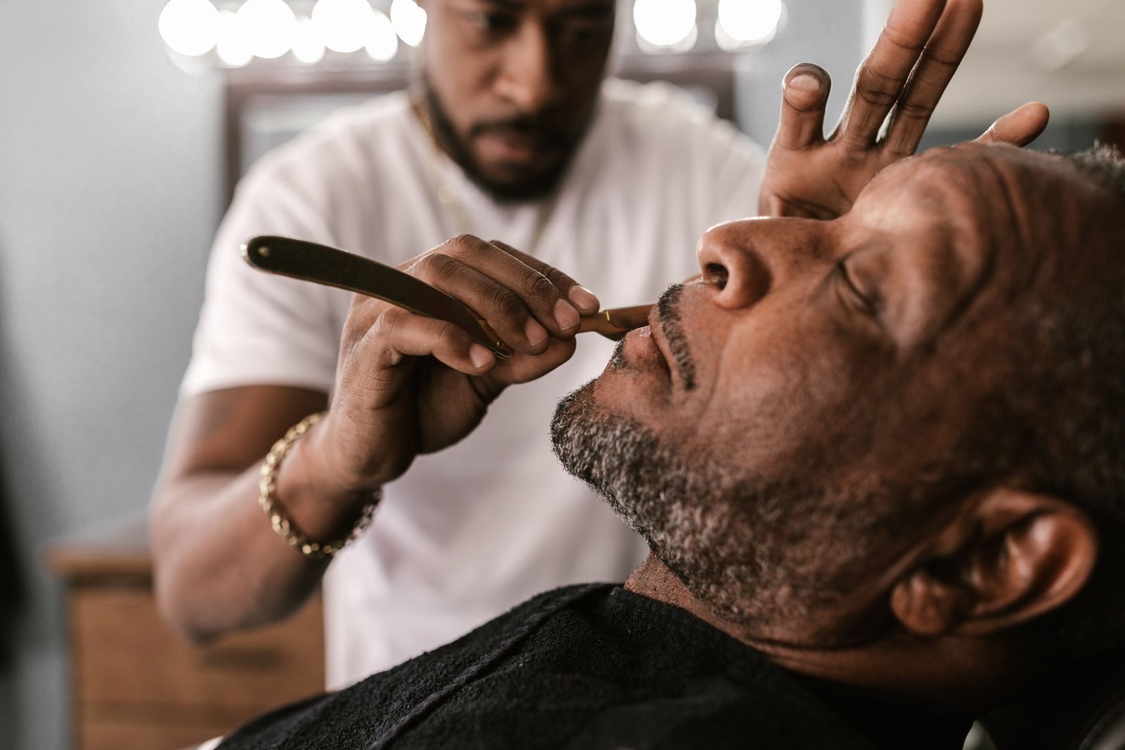 Barber giving a client a straight razor shave