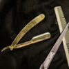 Brass straight razor, scissors and comb on black leather