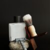 Aftershave bottle, shaving brush and safety razor on a stone
