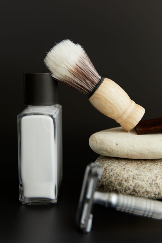 Aftershave bottle and brush resting on stacked stones