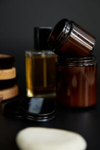 Amber jars of pomade with a bottle of hair tonic and a bar of soap