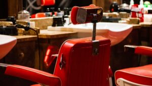 Row of red leather barber chairs in front of the stations