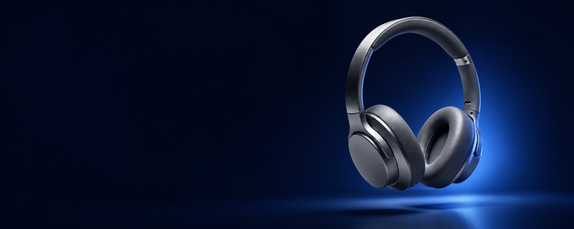 Gray over-ear headphones against a deep blue studio background