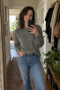 Customer mirror selfie wearing the heather grey boatneck knit jumper and mid-blue jeans