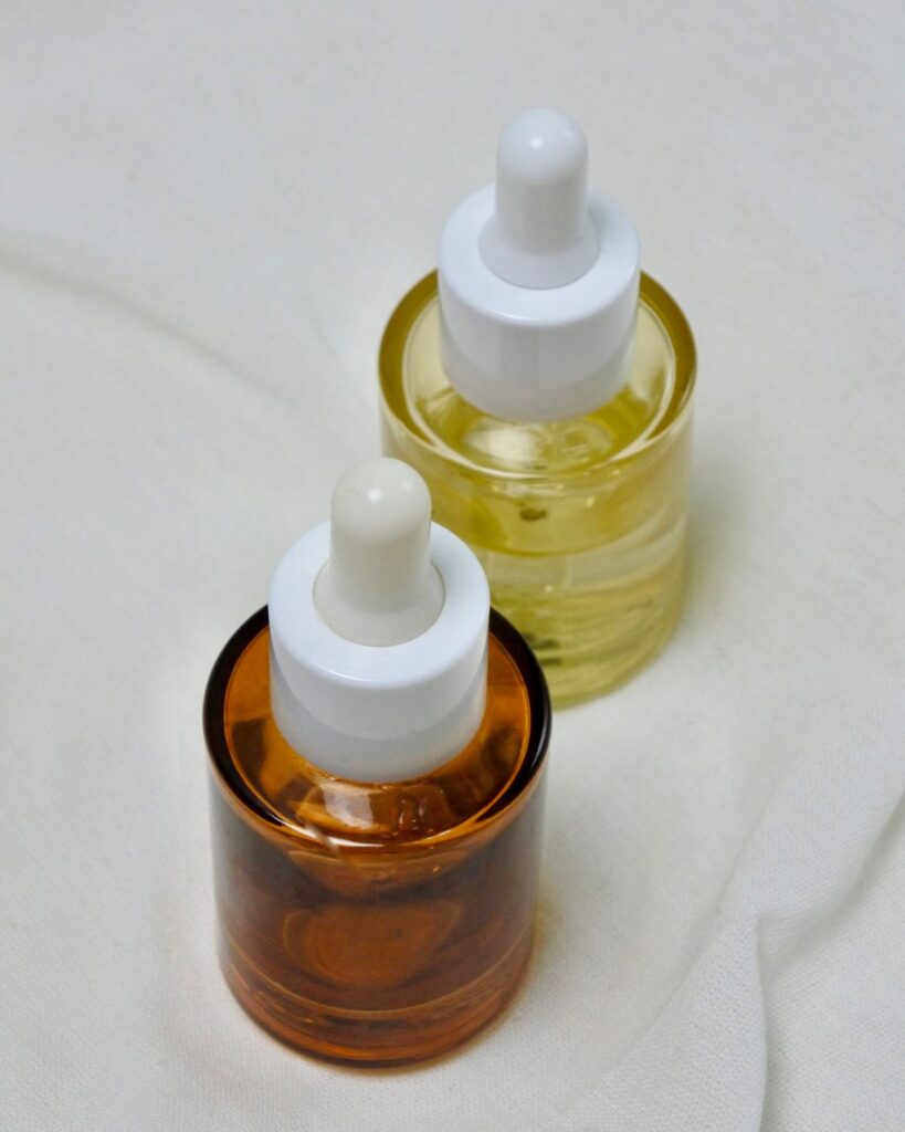 Amber and yellow dropper bottles on white fabric