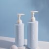 Two pale blue pump bottles on a blue background