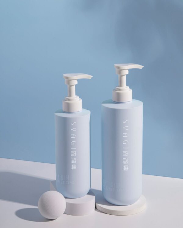 Two pale blue pump bottles on a blue background