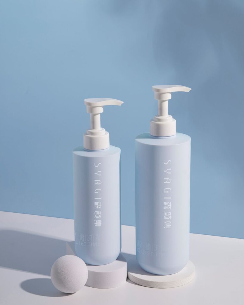 Two pale blue pump bottles on a blue background