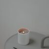 Lit white candle on a grey tray with matches