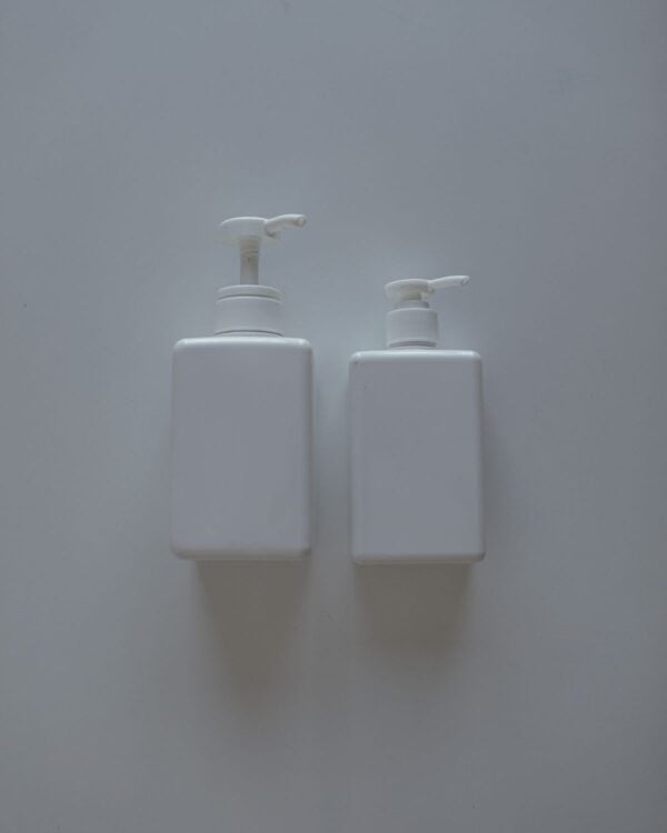 Two white pump bottles on a white surface