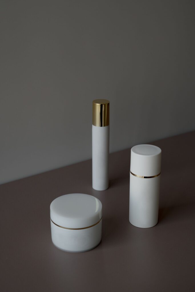 Minimalist white bottles and jar on a dark surface