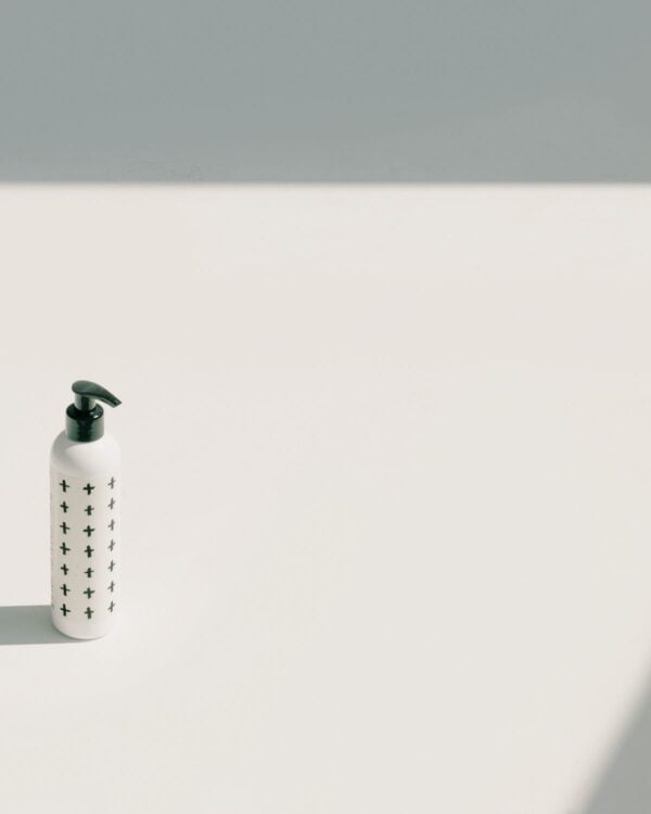 Small white bottle on a grey surface in soft light