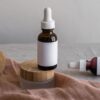Glass jar with wooden lid and dropper bottle on linen