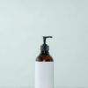 Amber pump bottle on a pale mint background
