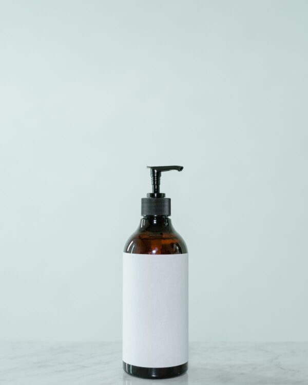 Amber pump bottle on a pale mint background