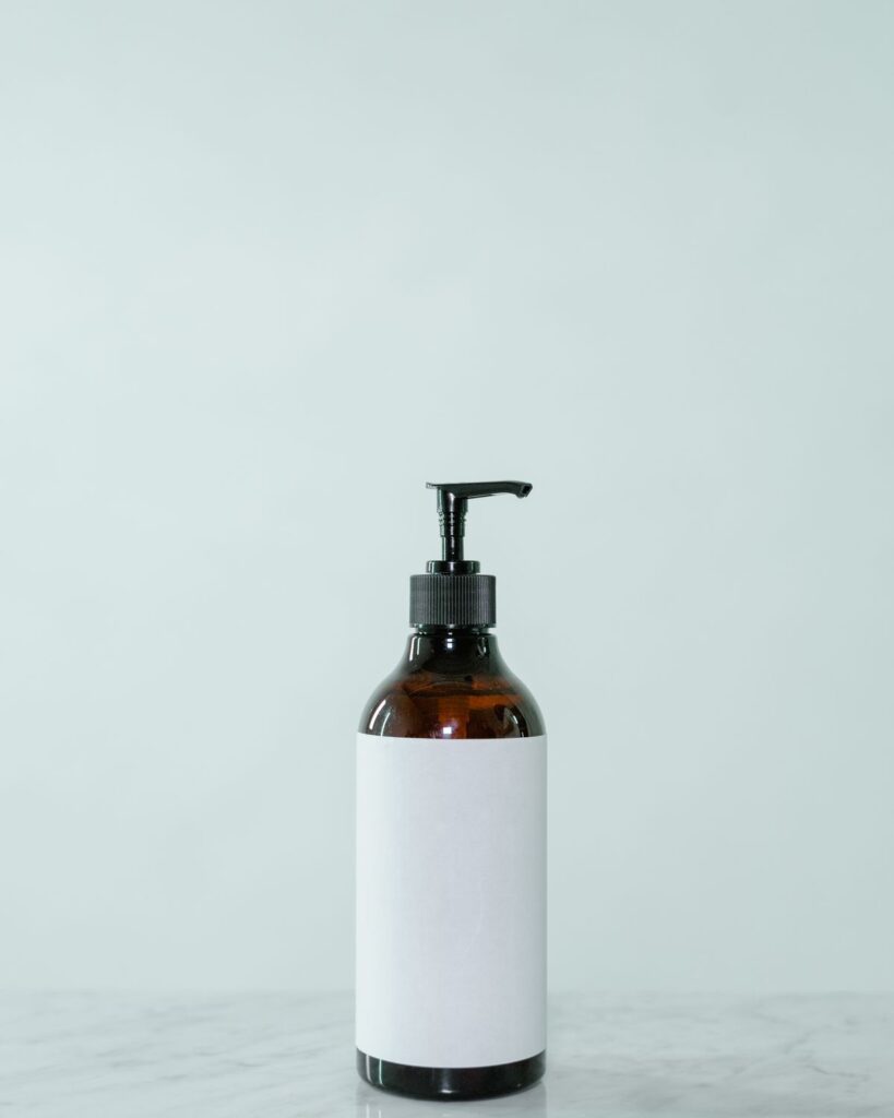 Amber pump bottle on a pale mint background