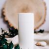 White deodorant stick in front of a wood slice