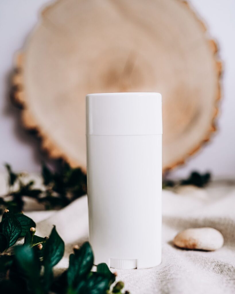 White deodorant stick in front of a wood slice