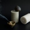 Calming still life with a stone, candle and incense bowl on black