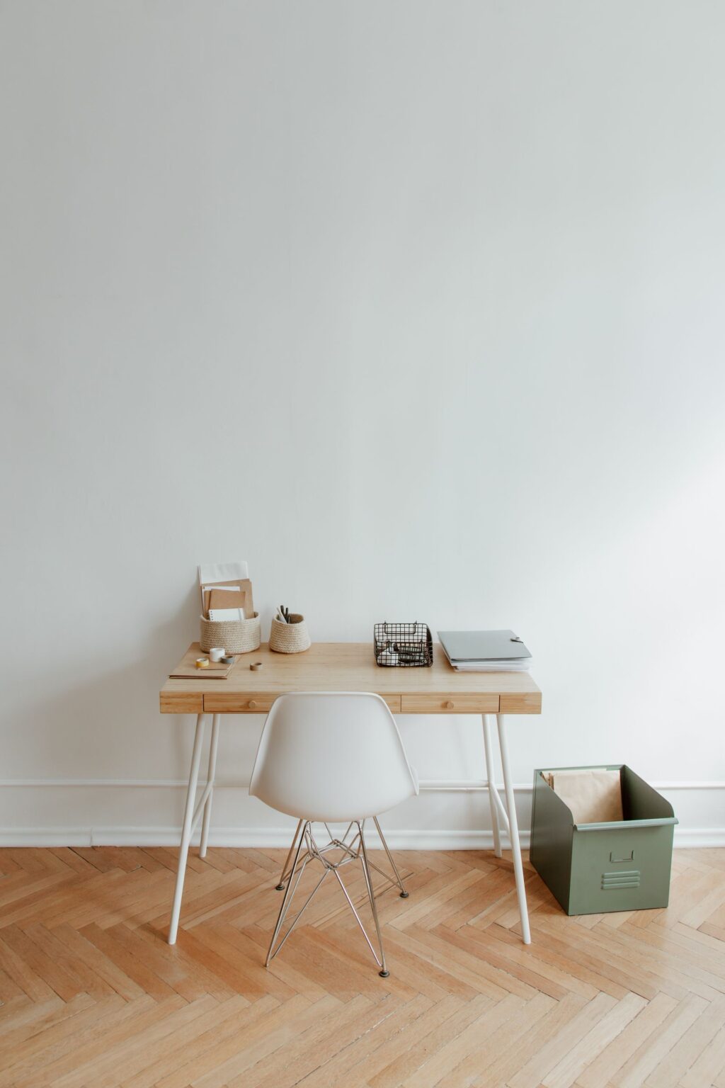 Oak writing desk with a white chair against a white wall
