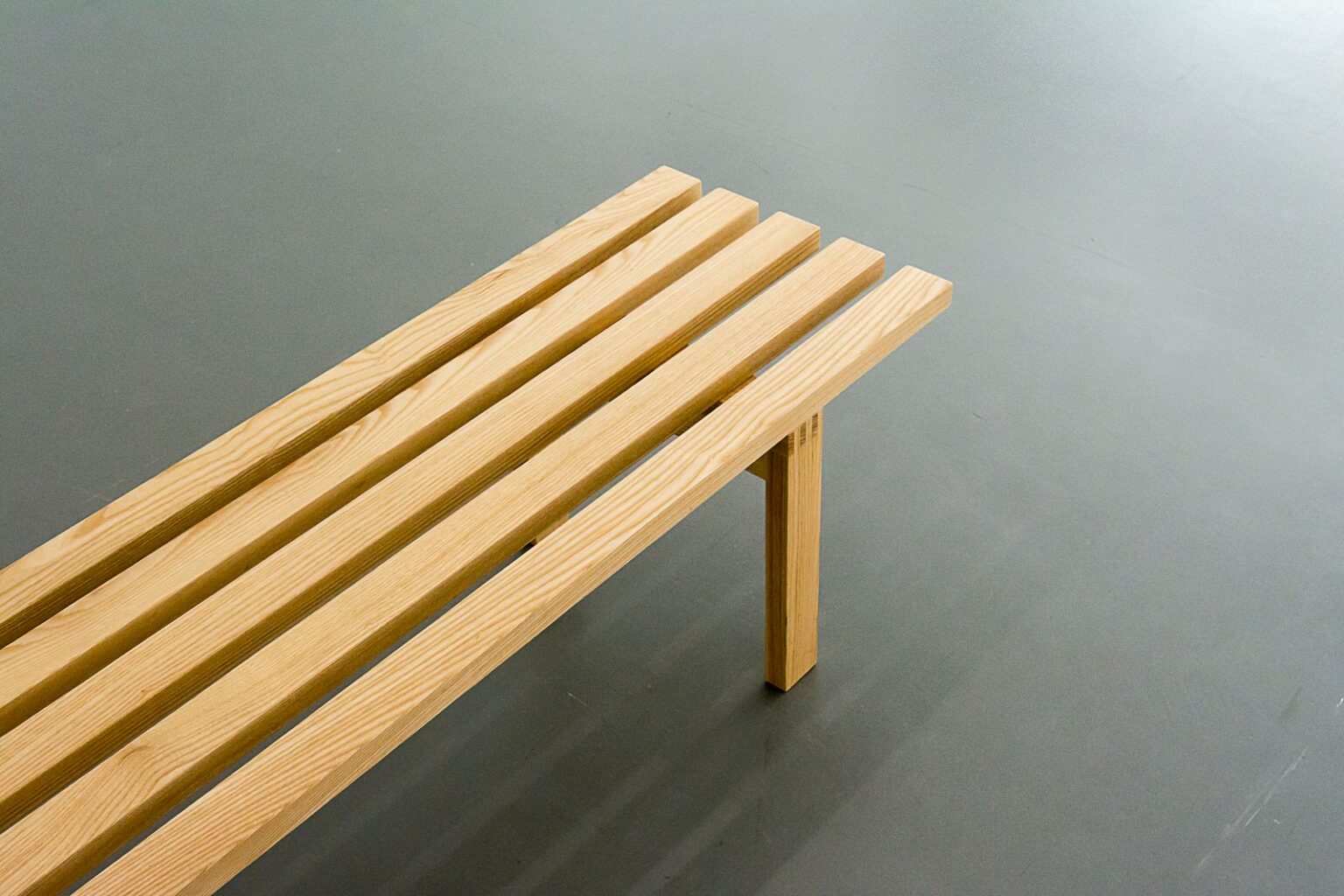 Slatted oak bench on a grey background
