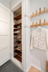 Low wooden shoe rack in a bright entryway
