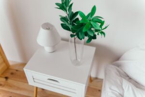 White nightstand with a small plant