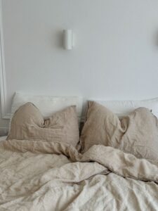 Beige linen bedding on an unmade bed