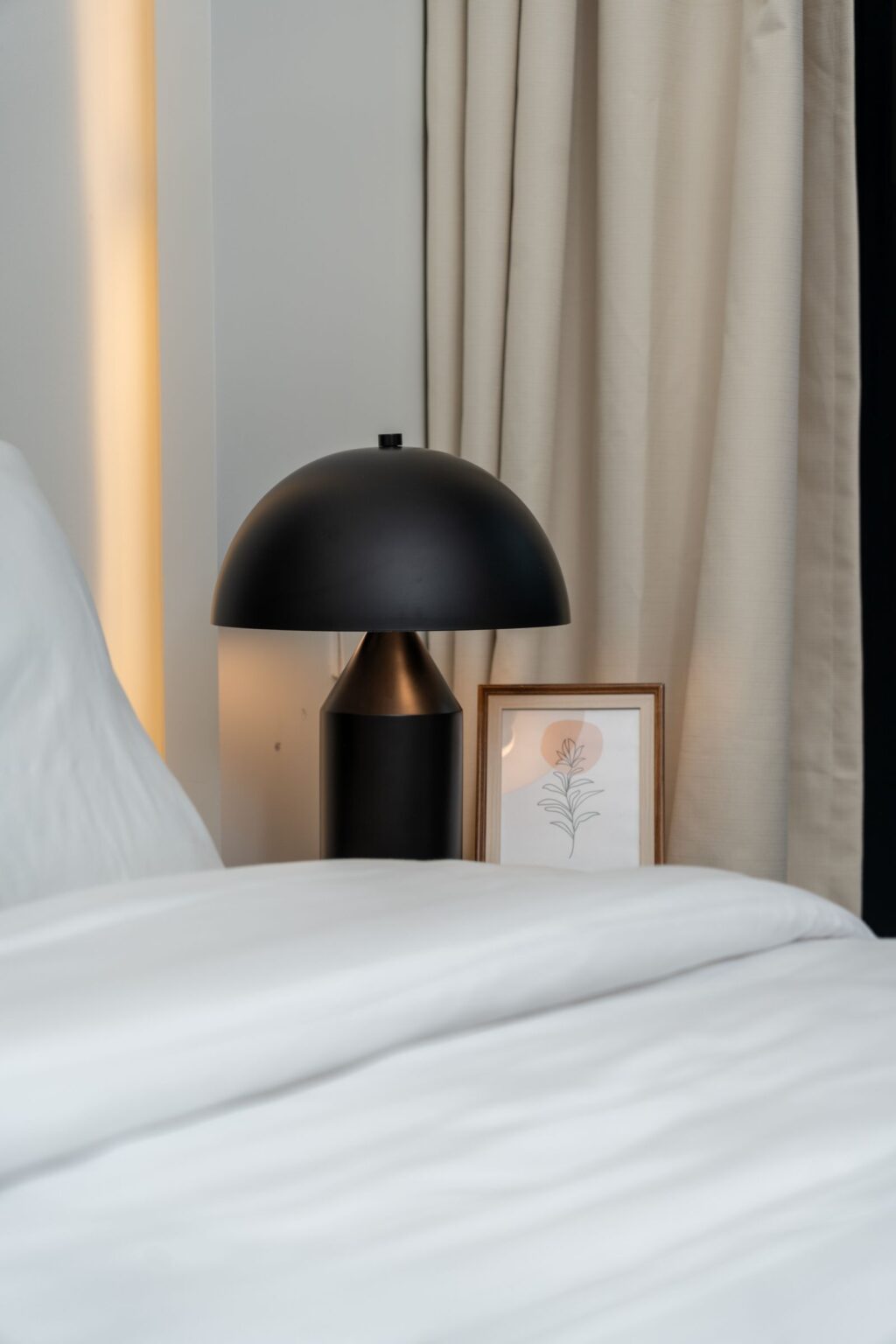 Black dome table lamp on a bedside table