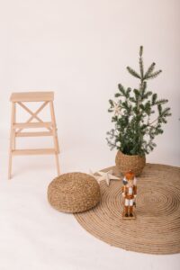 Rolled jute rug beside a wooden chair and plant